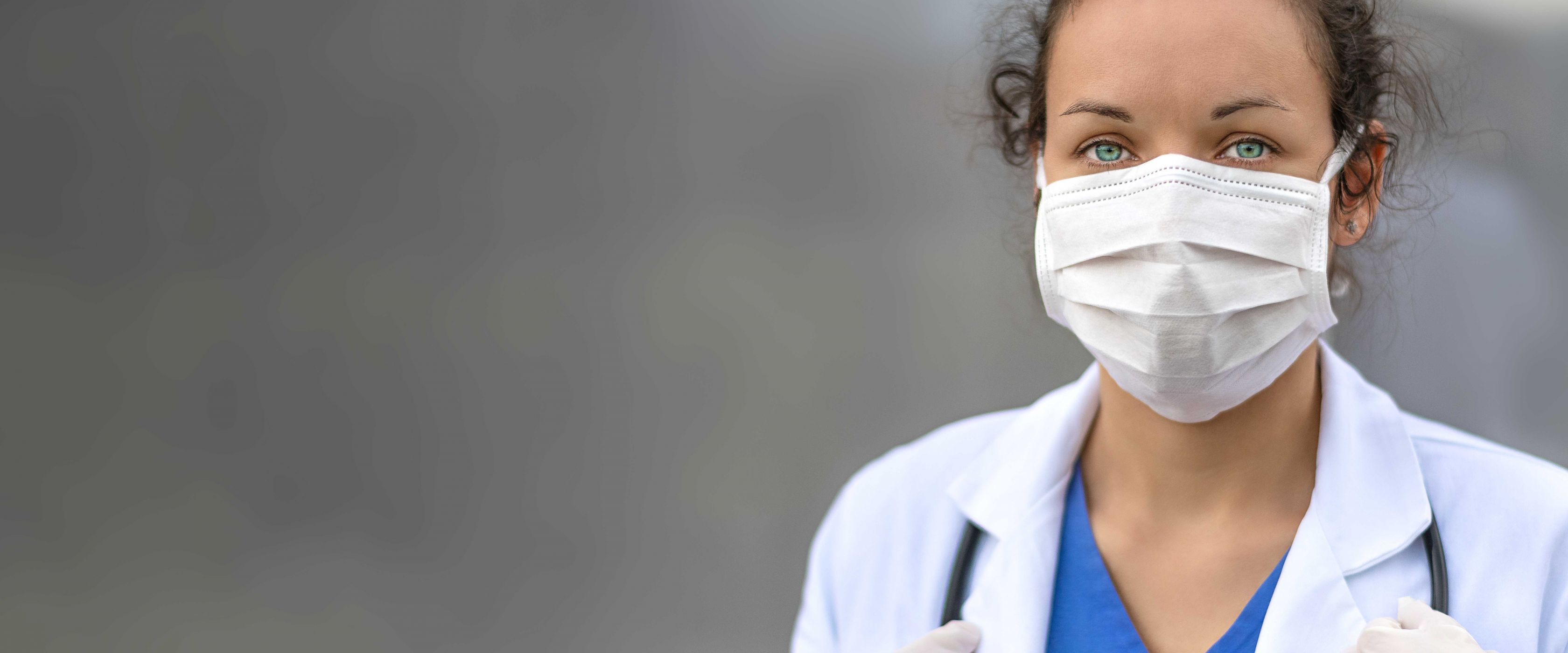 woman wearing lab coat and mask