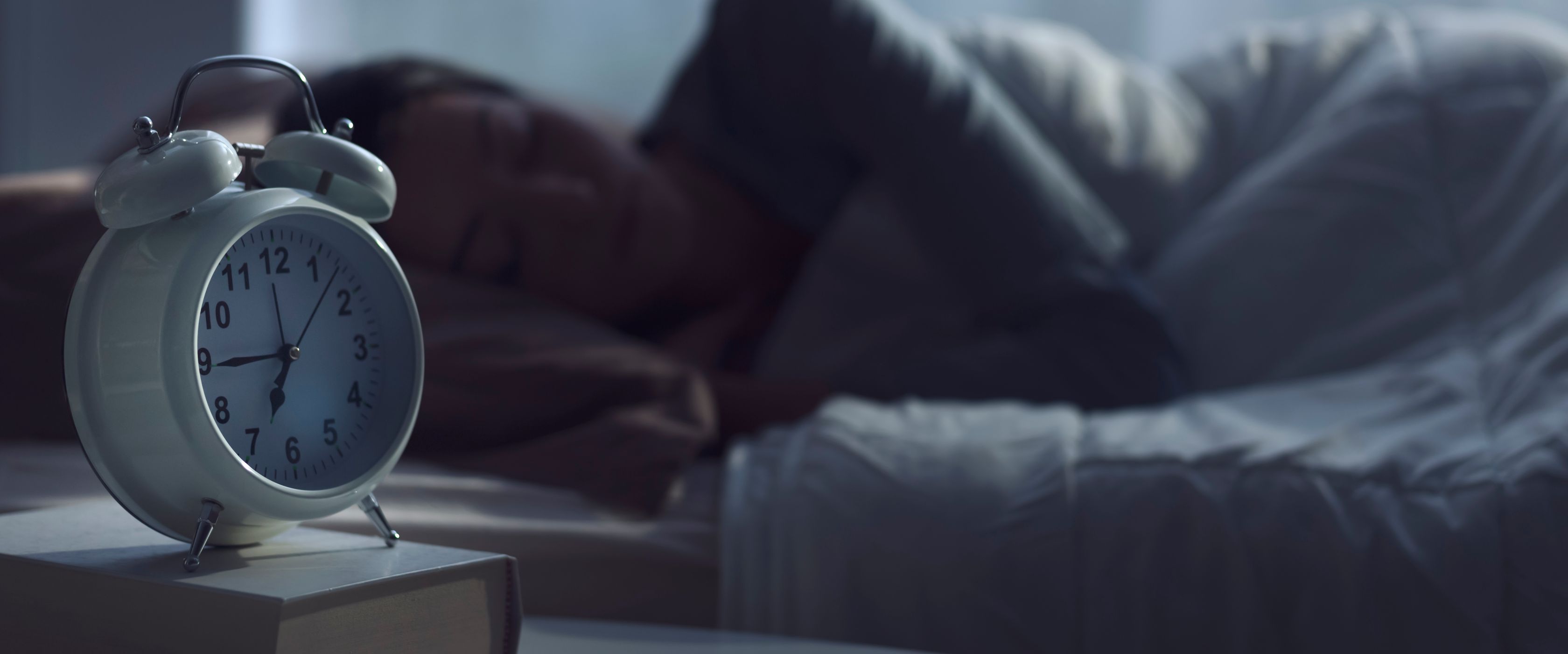 Woman sleeping with alarm clock next to her