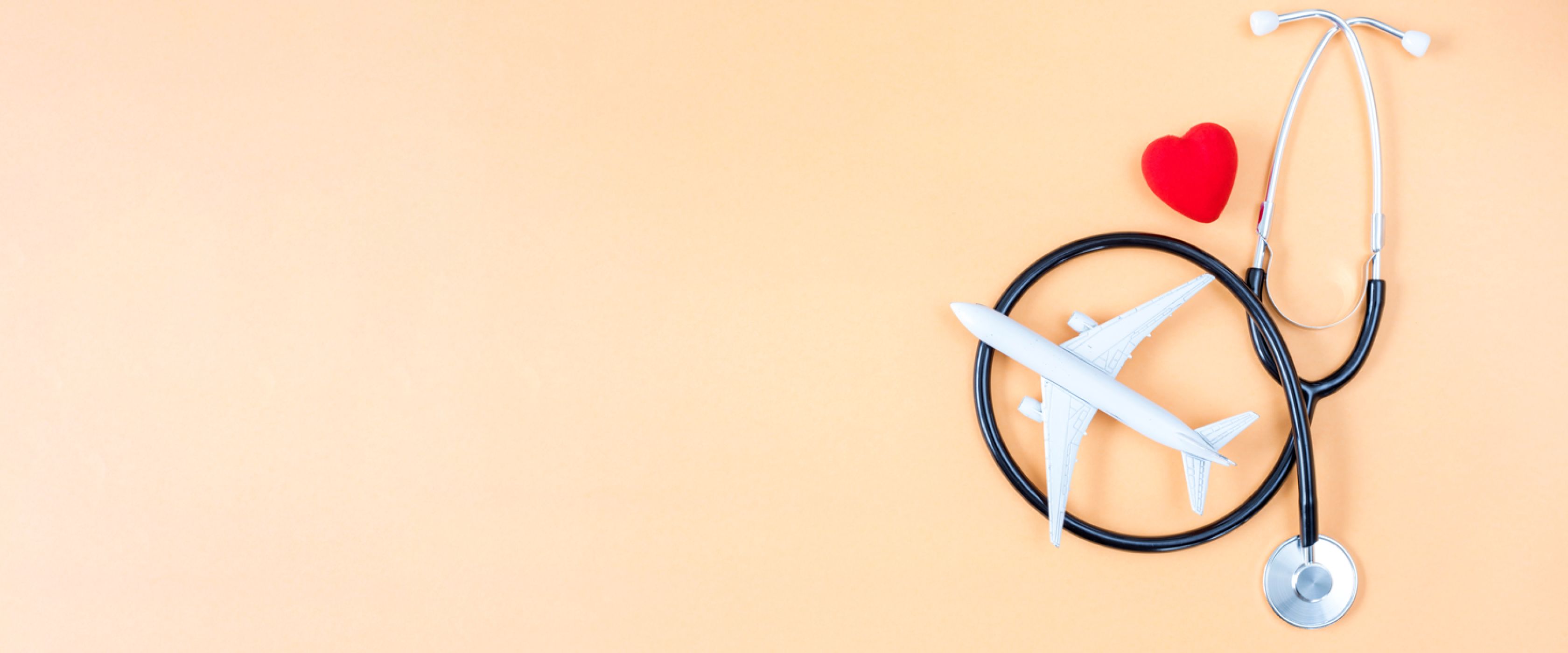 Plane and stethoscope over orange background