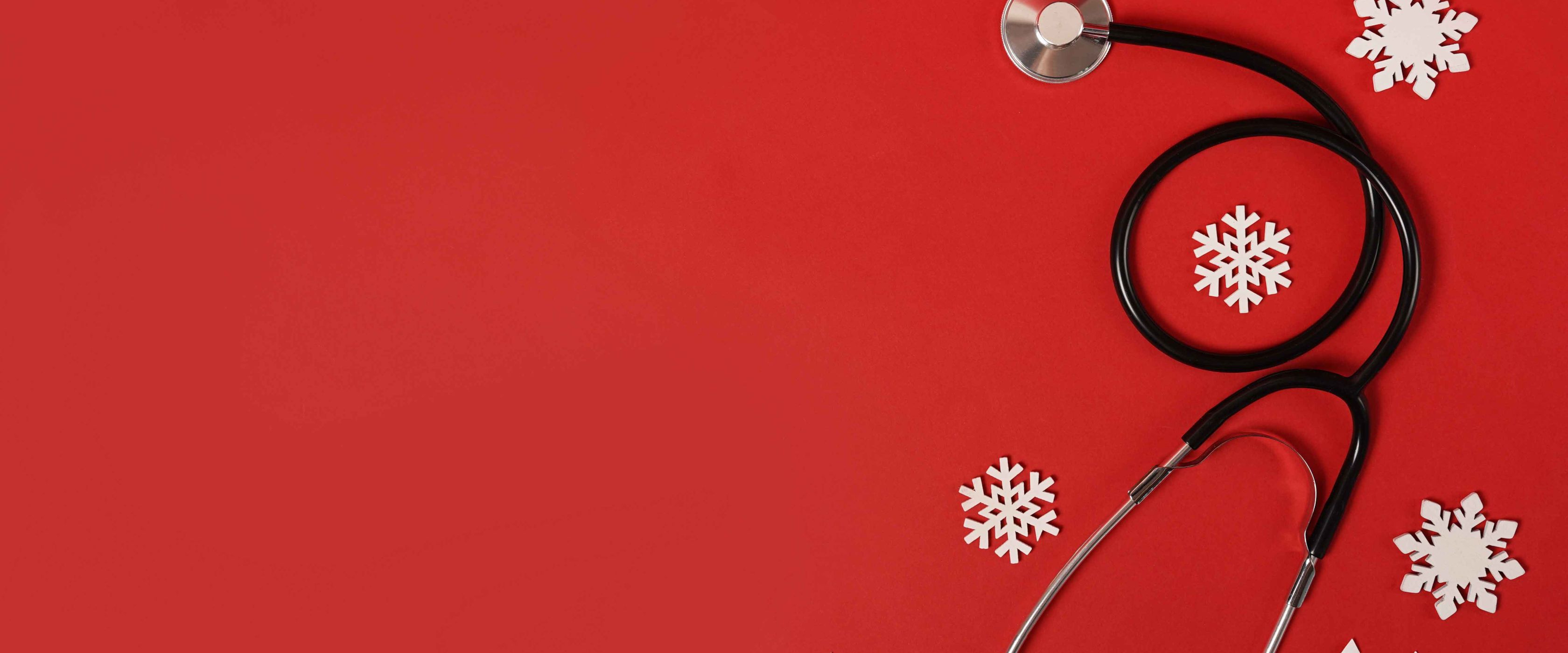 Stethoscope on red background with snowflakes