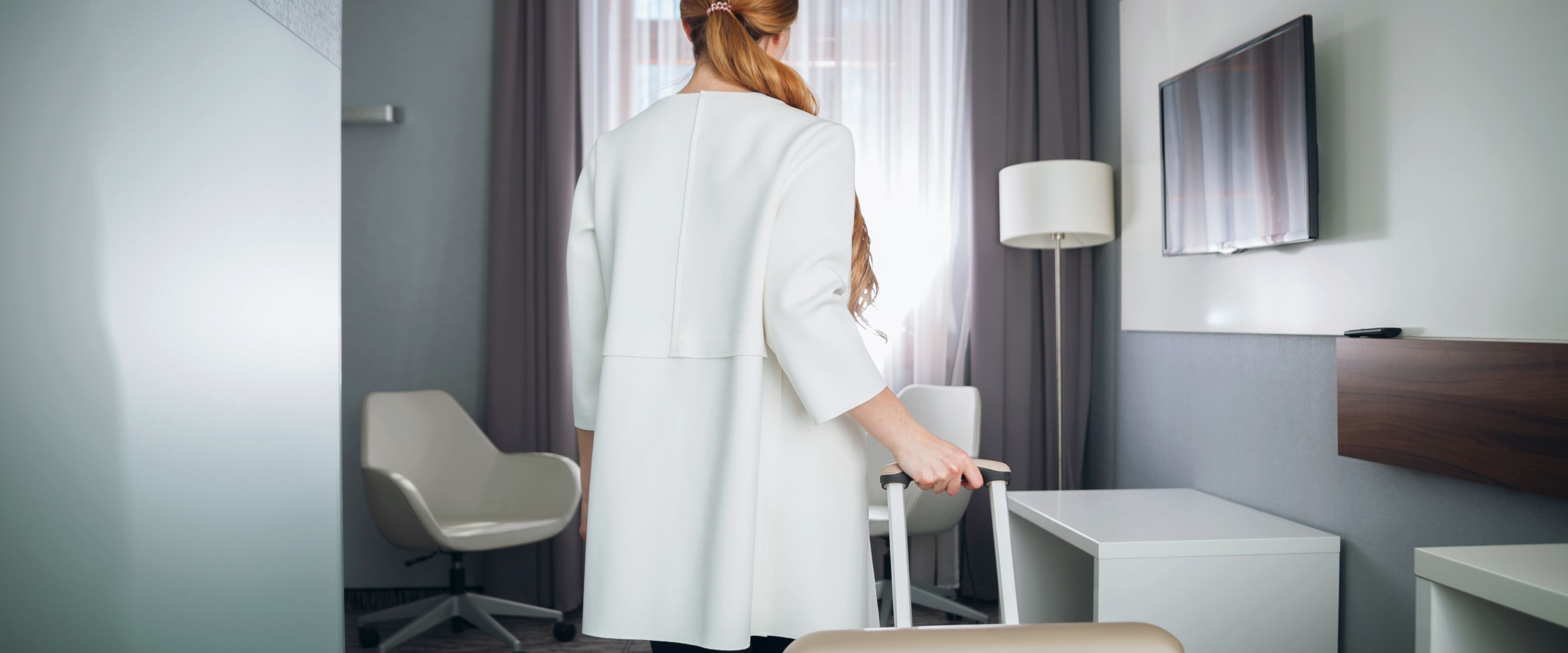 Therapist enters short-term furnished apartment with suitcase