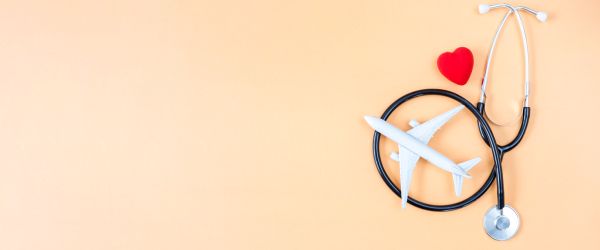 Plane and stethoscope over orange background