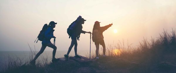 Three people hiking near ocean