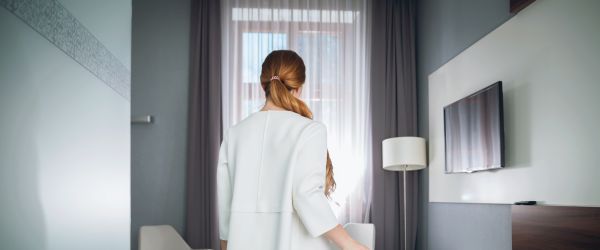 Therapist enters short-term furnished apartment with suitcase