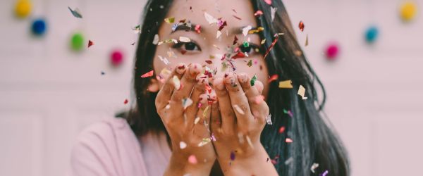Girl celebrating by throwing confetti