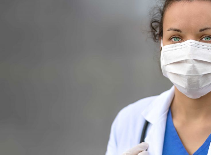 woman wearing lab coat and mask