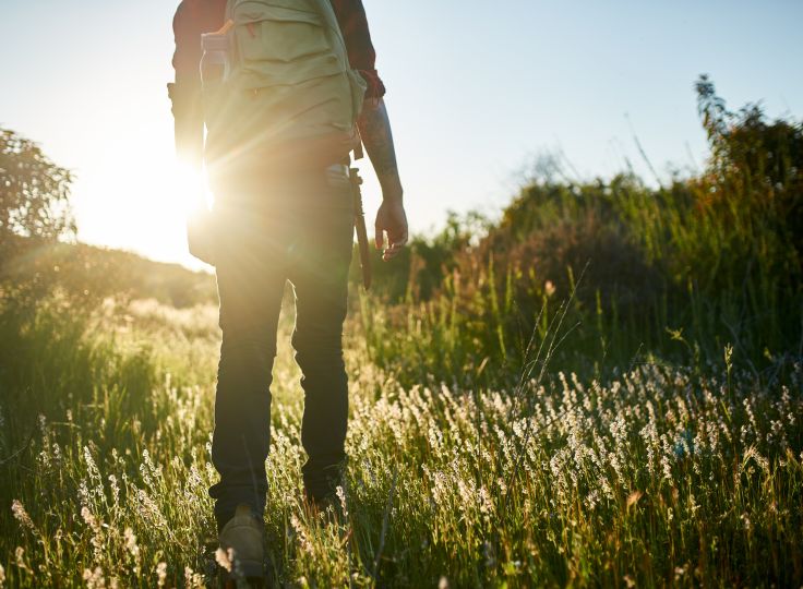 Man hiking through grass 