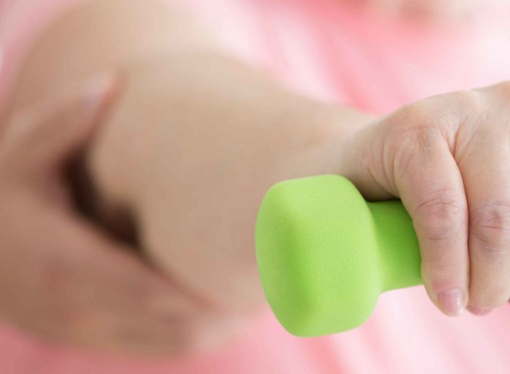 Woman holding weight during physical therapy