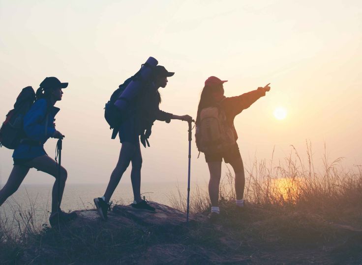 Three people hiking near ocean