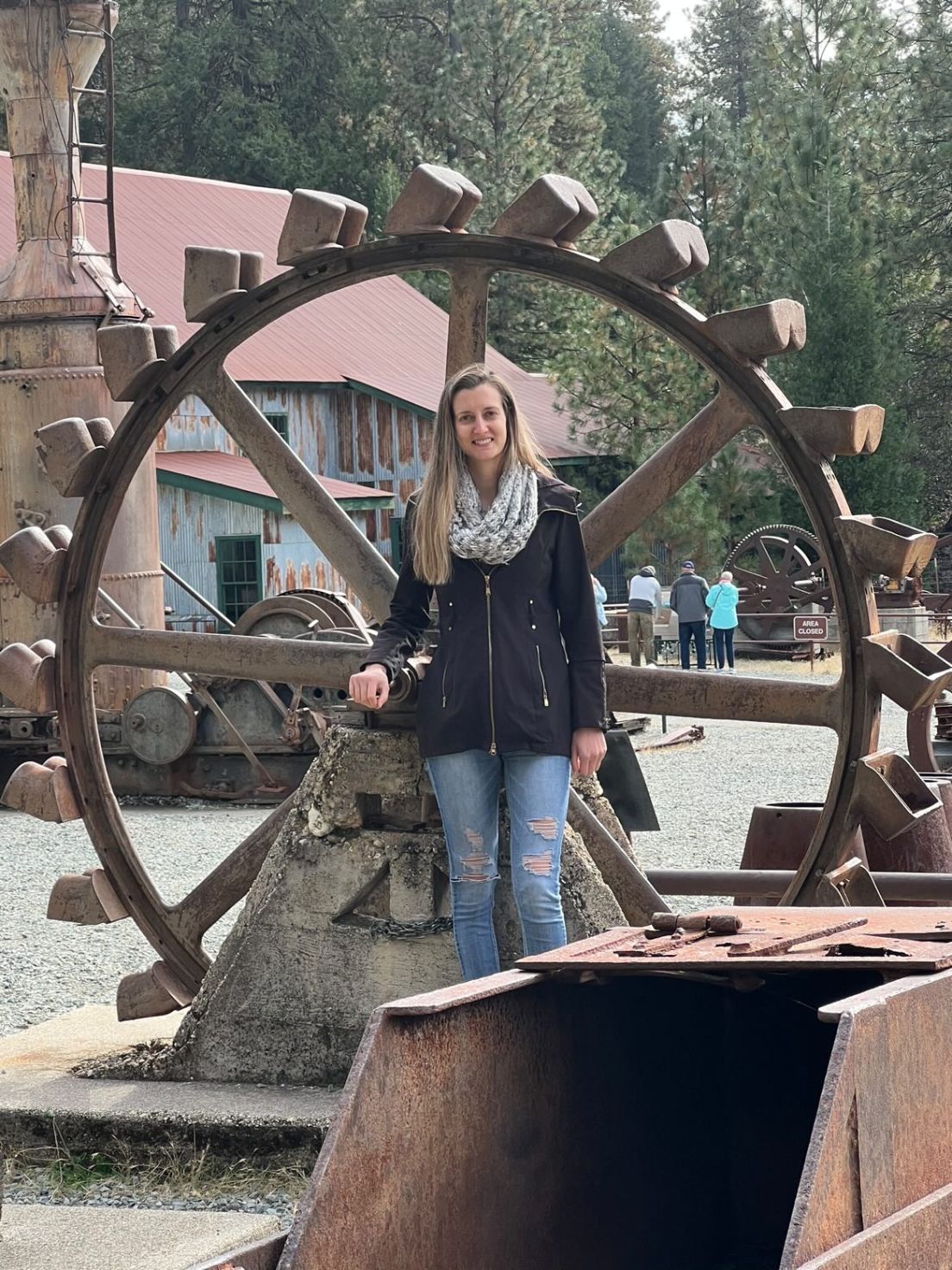 Woman standing in front of water wheel