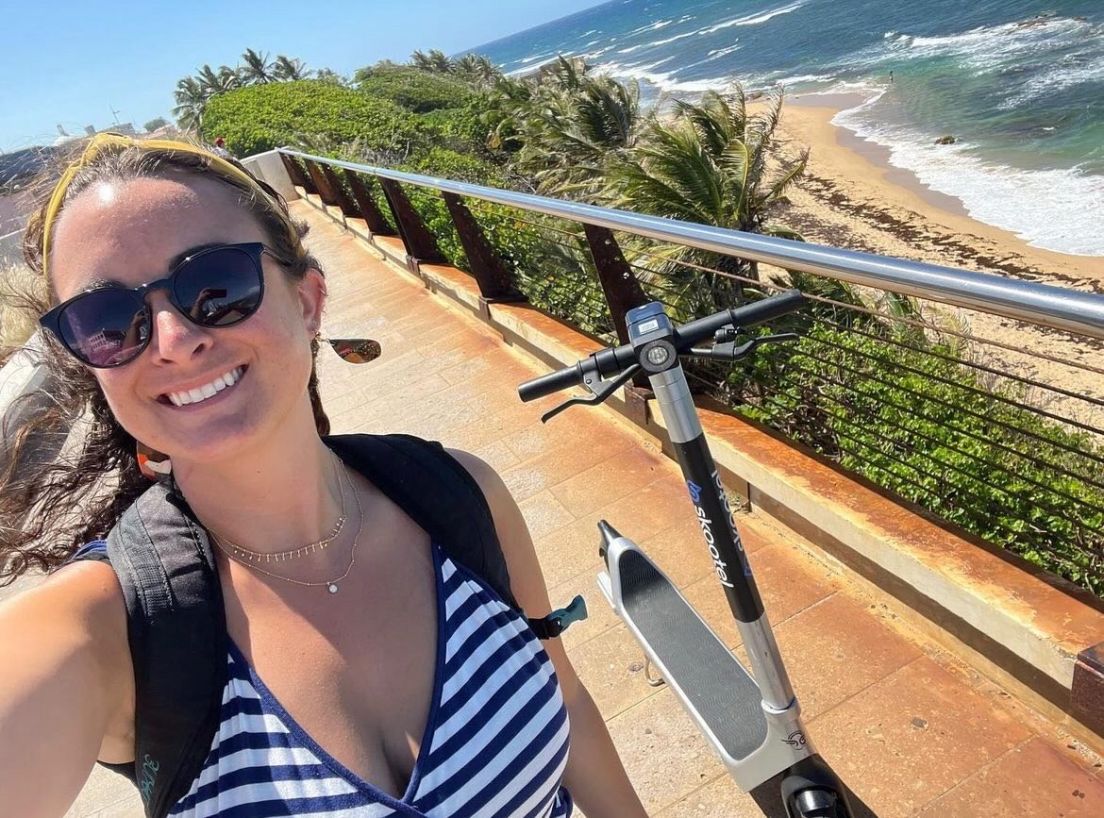 Woman standing next to ocean smiling