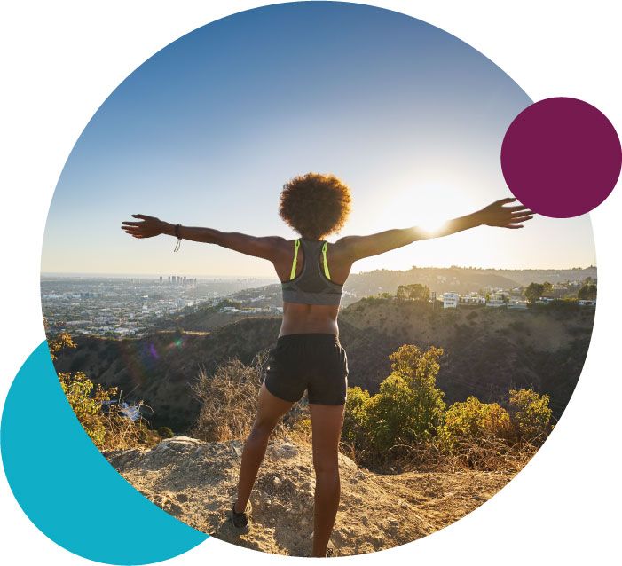 Woman standing arms raised on a hike