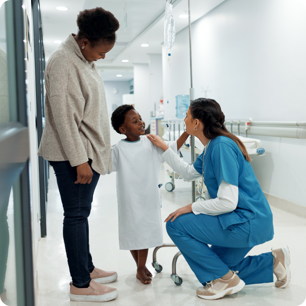 A clinician talks to a young patient and their mother