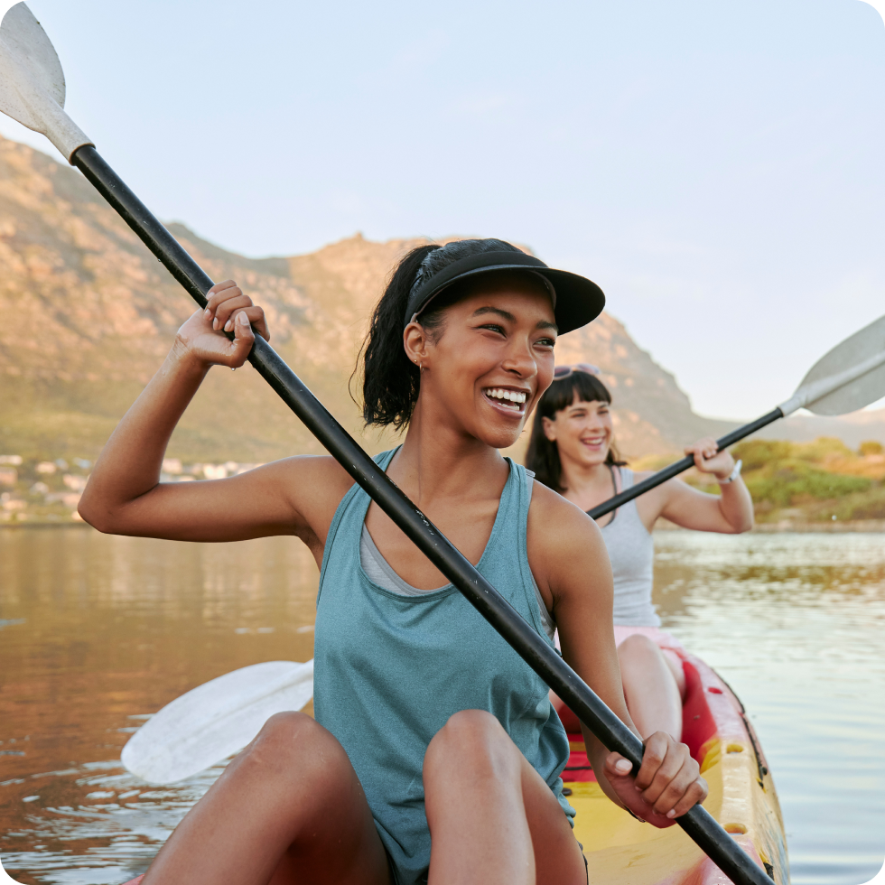 Two friends enjoy their assignment location by taking a weekend trip for paddleboarding