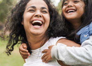 A clinician and her daughter laugh and play