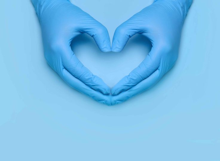 Healthcare worker making heart hands in latex gloves