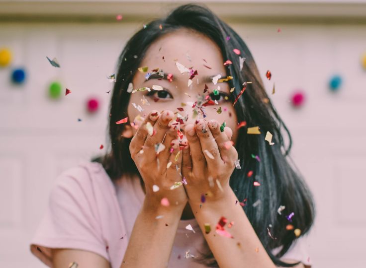 Girl celebrating by throwing confetti